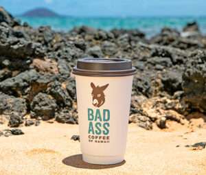 Bad Ass Coffee cup on the beach